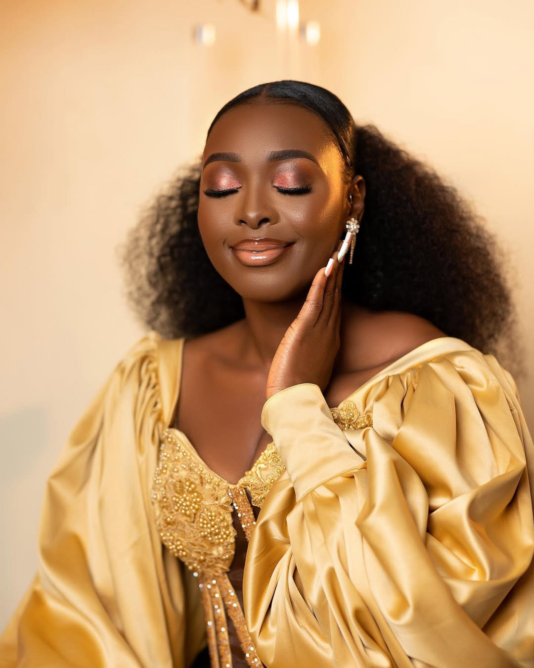 This is the close-up, high-glamour shot, which is often a look used for pre-wedding/bridal shoots. • Alt Text: Glamour pre-wedding portrait of a smiling woman in a golden gown with professional makeup. Photo by Birdy Images. • Title: Accra Bridal Portrait – Woman in Golden Gown by Birdy Images • Caption: Elegant bridal style for a pre-wedding look! A stunning portrait by Birdy Images. • Description: A beautiful, high-end glamour portrait of the bride-to-be in a gold dress. Birdy Images provides professional pre-wedding and glamour photography in Accra, Ghana, focusing on elegant styling. Glamour pre-wedding portrait of a smiling woman in a golden gown with professional makeup. Photo by Birdy Images.