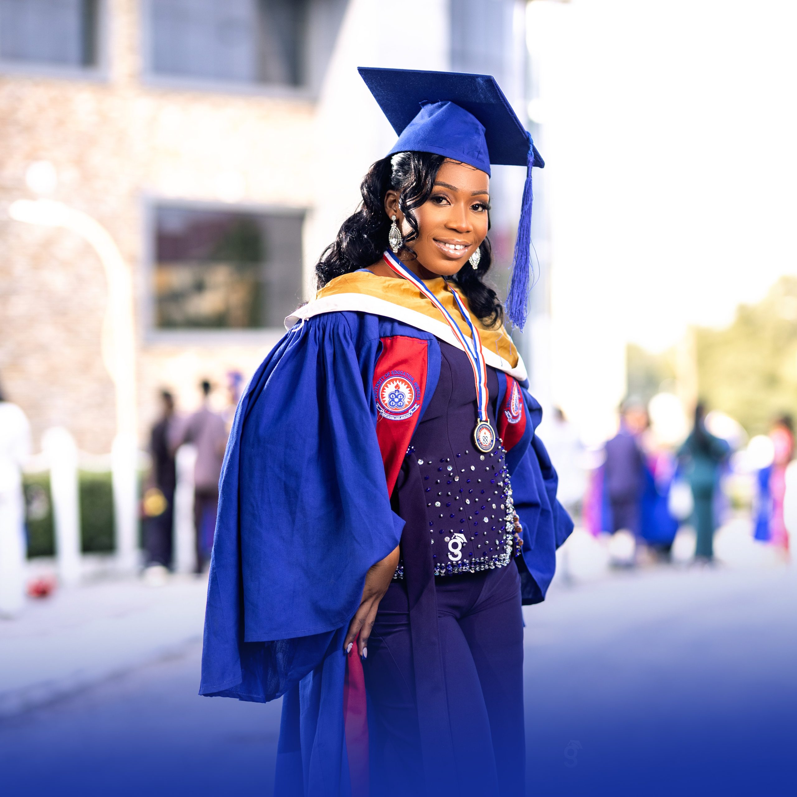 Detailed. Gradmoment close-up of UEW graduate in full academic regalia with a mortarboard